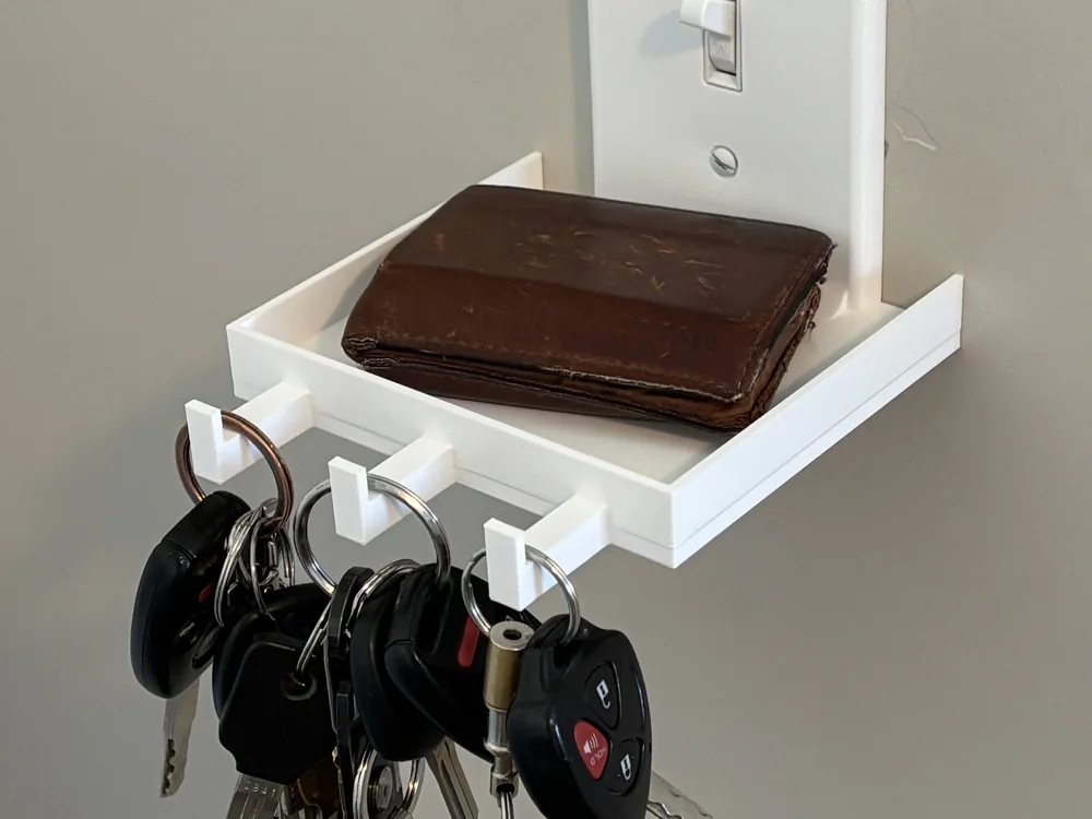 The light switch shelf holding keys beside a door